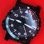 A black Dievas Vortex automatic watch with a black dial and bezel, featuring white Arabic numerals and hands, resting on a textured red background.