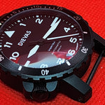 A black Diewas automatic watch with a black dial and white markings, shown on a textured red background.
