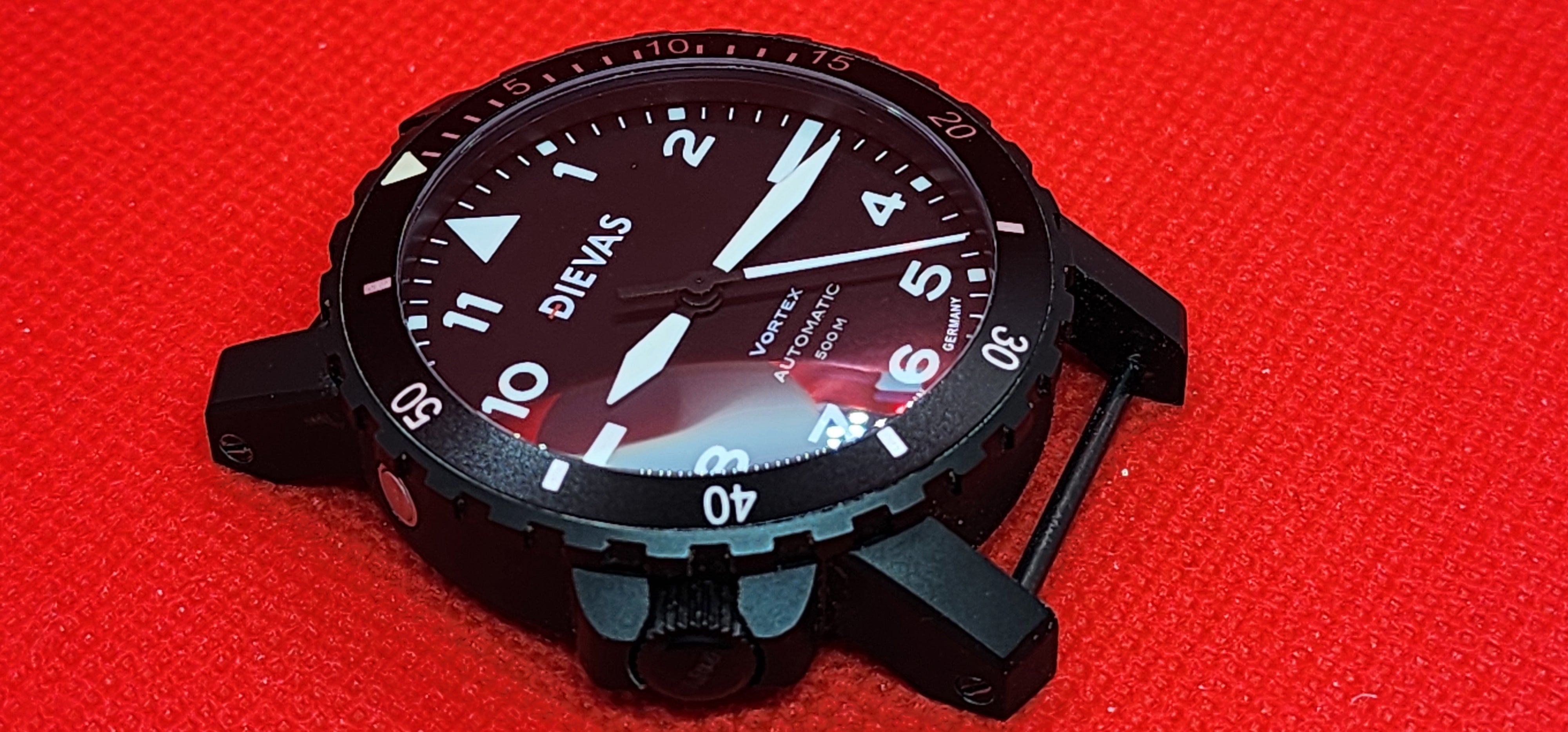 A black Diewas automatic watch with a black dial and white markings, shown on a textured red background.